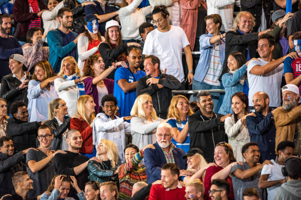 istock People in a stadium with hands on each other's shoulders 1130790171