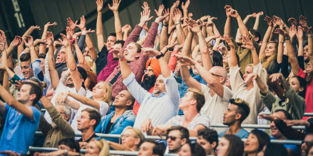 istock Crowd cheering for their team with arms raised 1130790191