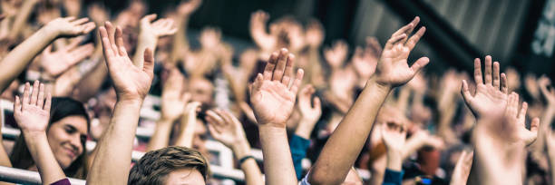 istock Crowd cheering for their team with arms raised 1130790211