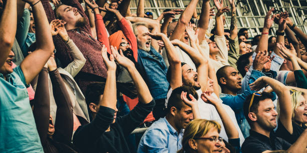istock People doing a Mexican wave on the tribunes 1130790237