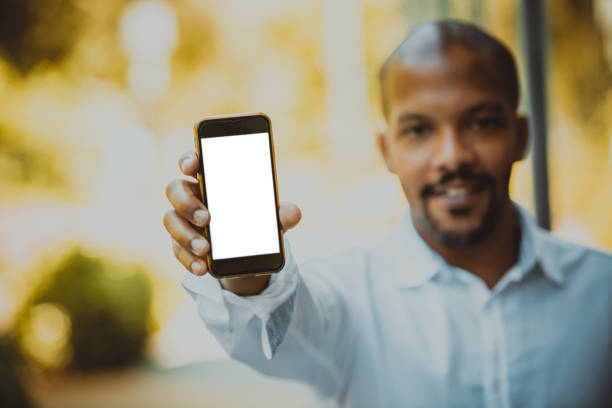 istock Young black African black entrepreneur holding hand cell phone with copy space screen for your advertising content before meeting with business partners. 1130792690