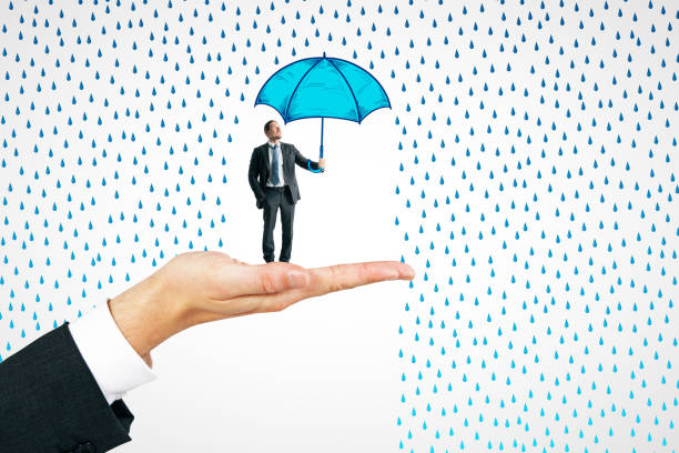 Happy senior man walking on rainy day under umbrella in the city. Looking at camera.