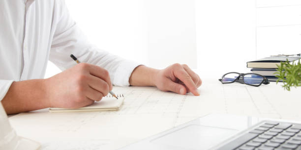 istock Architects working on blueprint, real estate project. Architect workplace - architectural project, blueprints, ruler, calculator, laptop and divider compass. Construction concept. Engineering tools. 1130795296
