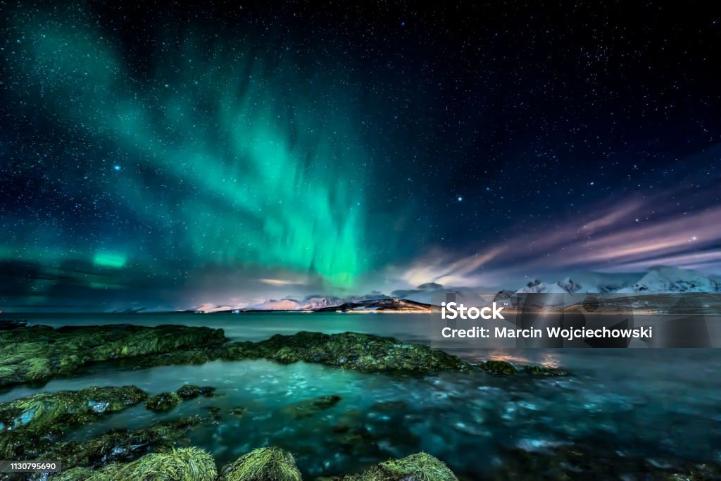 Amazing aurora borealis - northern lights - view from coast in Oldervik, near Tromso city -  north Norway Aurora Borealis Stock Photo