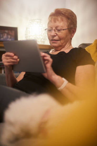 Senior woman online A happy smiling senior woman using her digital tablet free bingo stock pictures, royalty-free photos & images