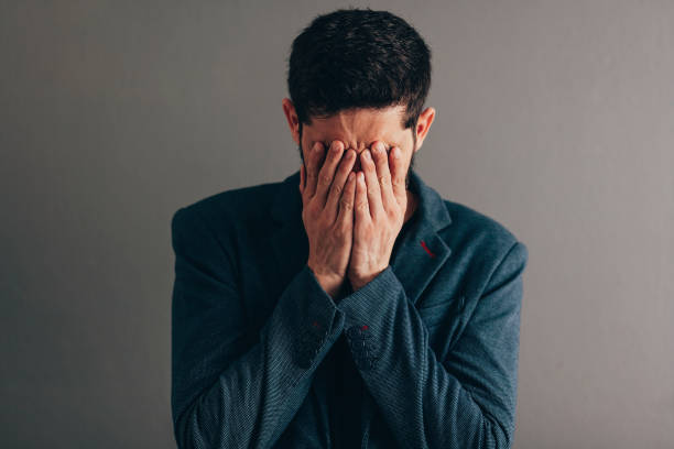 istock businessman wearing blue suit with sad expression covering face with hands while crying. Depression concept. 1130802782