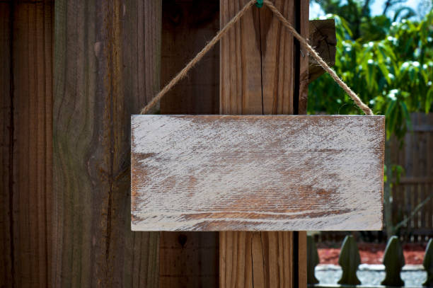 istock blank rustic sign hanging from wooden fence 1130804774