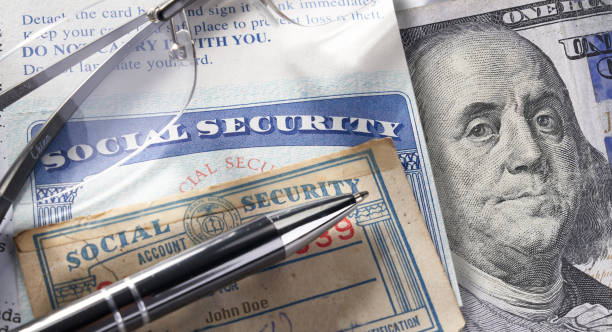 Social Security Card with money pen and glasses: $100 dollars Social Security Card with calculator and money social security social security card identity us currency stock pictures, royalty-free photos & images