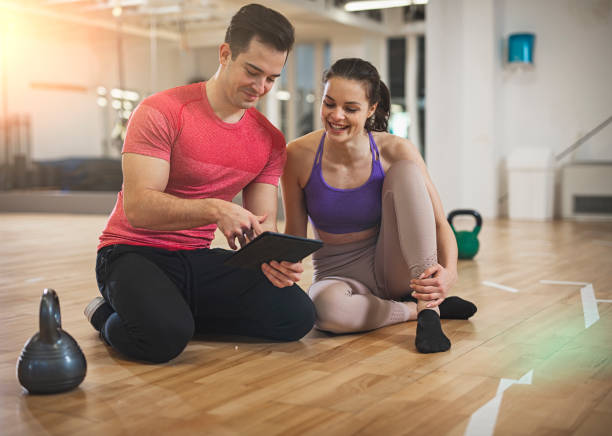 istock Young  woman and her personal trainer in gym 1130809189
