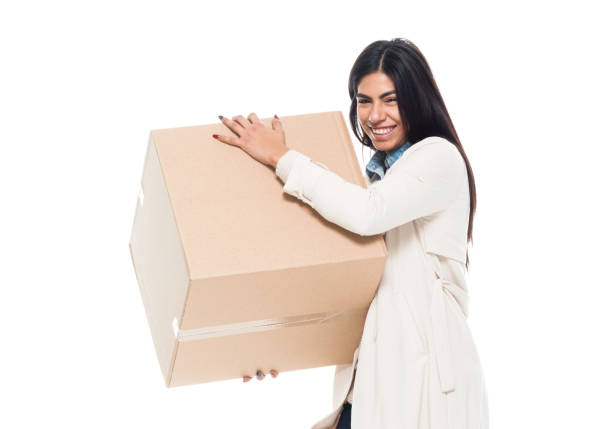 istock Attractive young latino female is holding a box 1130809369