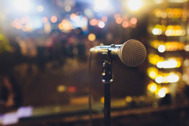 istock Close up microphone on stage in concert hall restaurant or conference room blurred background. 1130810508