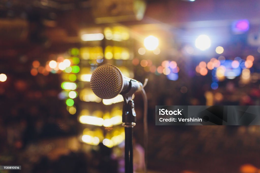 Close up microphone on stage in concert hall restaurant or conference room blurred background. Close up microphone on stage in concert hall restaurant or conference room blurred background Concert Stock Photo