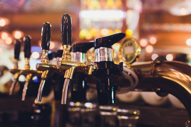 istock beer tap pours draught lager beer serving in a restaurant or pub. 1130810519