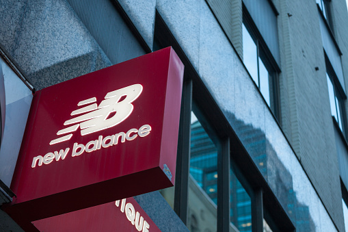 Picture of the New Balance sign with their logo on a window of their main retailer in Montreal, Canada, Quebec. New Balance is an American multinational corporation, one of the world's major sports footwear and sneakers manufacturers