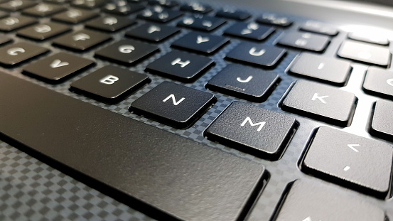 teclado en ángulo lateral centrado en la letra M. Keyboard en tonos de gris y negro. photo
