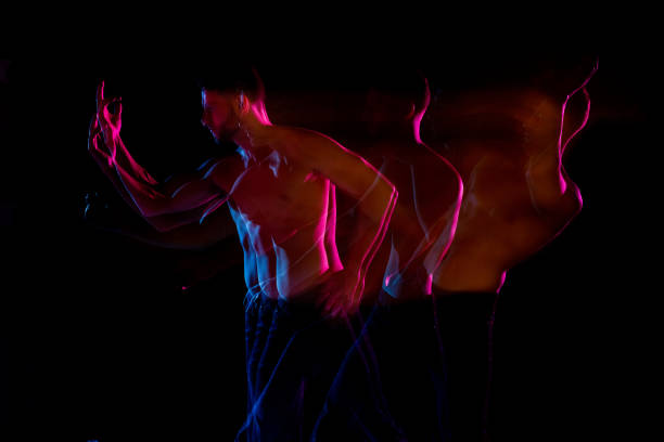 istock Shirtless man dancing with color gel lights 1130817598