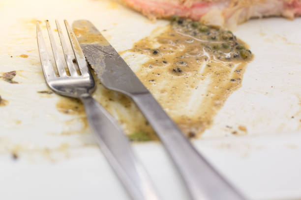 Knife and fork with"n Sauce gravy in plate after steak