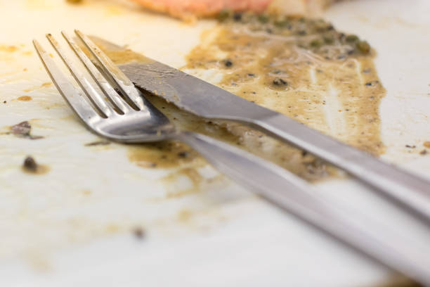 Knife and fork with"n Sauce gravy in plate after steak
