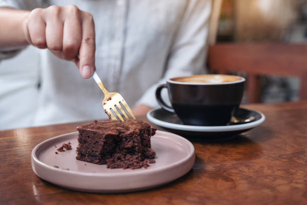 istock A woman cutting brownie cake with fork 1130821668