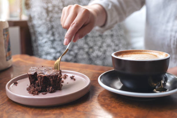 istock A woman cutting brownie cake with fork 1130821678