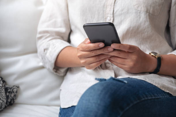 istock a woman holding , using and looking at smart phone 1130821682