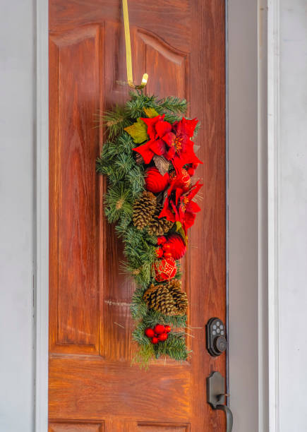 istock Leafy door decoration with flowers and pinecones 1130828354