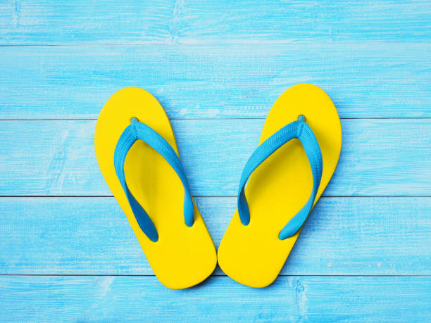istock yellow rubber flip flop on blue wooden background 1130828423