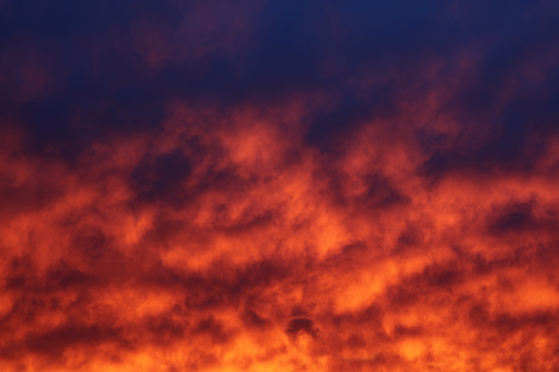The sky and brightly illuminated clouds at sunset as the background for design.