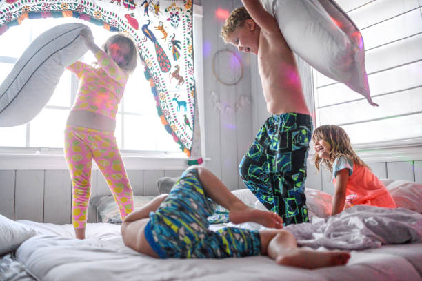 pelea de almohada baile fiesta de pijamas caos y niños - lucha con almohada fotografías e imágenes de stock