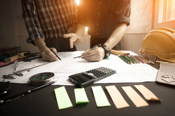 istock Concept Agreement between the employer and architect Nick and desk of Architectural project in construction site or office building 1130834105
