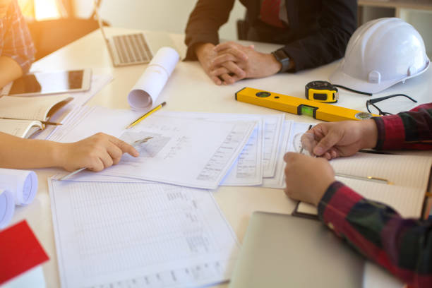 istock Concept Agreement between the employer and architect Nick and desk of Architectural project in construction site or office building 1130834162