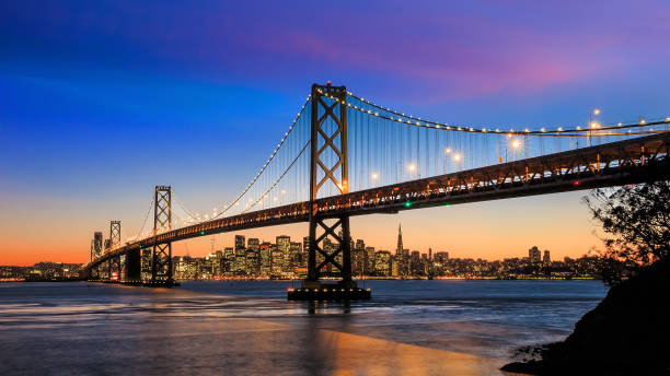 horizon de san francisco et pont de baie au coucher du soleil, californie - san francisco oakland bay bridge photos et images de collection