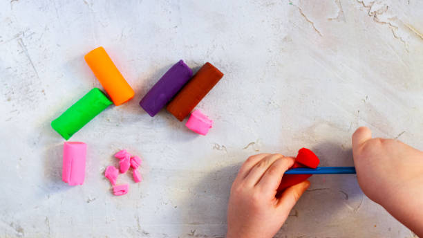 Colorful clay plasticine, modelling clay pieces with child's hands, horizontal, education, child psychology, neuropsychology fine motor skills manual dexterity copy space health mental Colorful clay plasticine, modelling clay pieces with child's hands, horizontal, education, child psychology, neuropsychology fine motor skills manual dexterity copy space mental health neuropsychology stock pictures, royalty-free photos & images