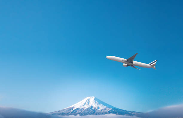 Airplane frying over the Snow Mountain Fuji background.  view of Fuji-san, the highest mountain in Japan stock photo