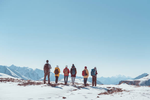 Big group hikers tourists friends mountain pass or top Big group of hikers or tourists or friends stands on mountain pass or top and looks at mountains. Space for text group of people people recreational pursuit climbing stock pictures, royalty-free photos & images