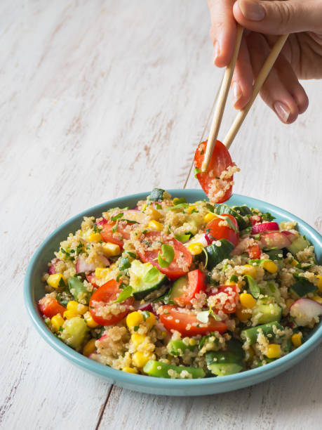 istock Salad with quinoa hand eating chopsticks. Close up 1130849884