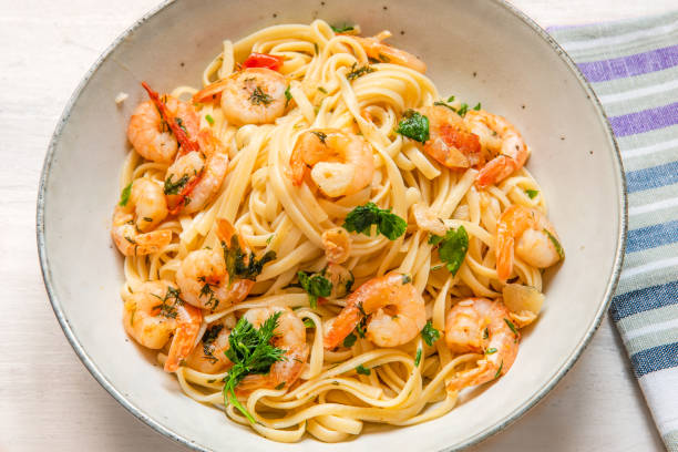 istock Linguine with shrimps on a rustic plate close-up, top view - traditional Mediterranean pasta with seafood, Italian cuisine. 1130852242