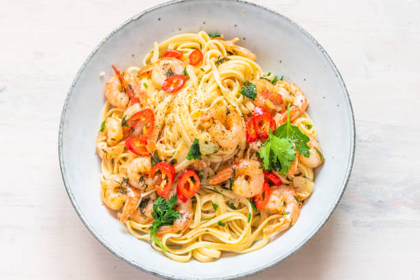 istock Linguine with shrimps on a rustic plate close-up, top view - traditional Mediterranean pasta with seafood, Italian cuisine. 1130852766