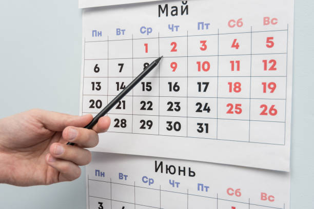 istock Pencil hand indicates long weekends and holidays on a wall calendar 1130857557