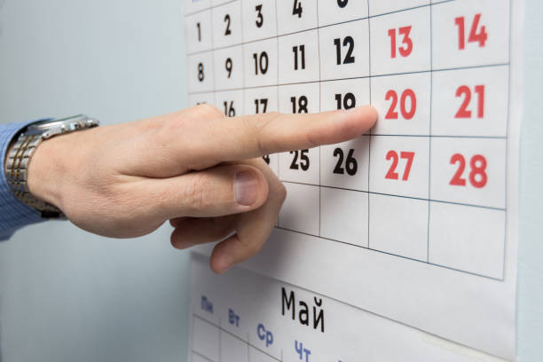 istock The office specialist's hand points to the day off on the wall calendar 1130857561