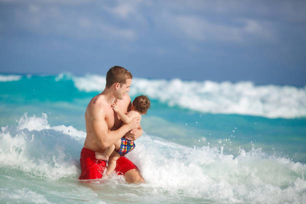 istock Young father with little son on tropical beach 1130857916