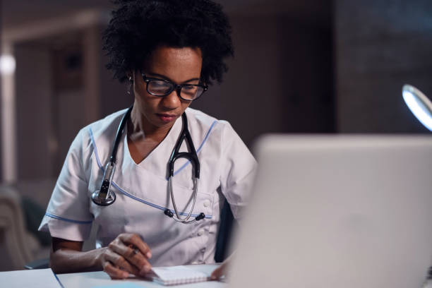 istock African American female doctor reading notes at office desk. 1130858886
