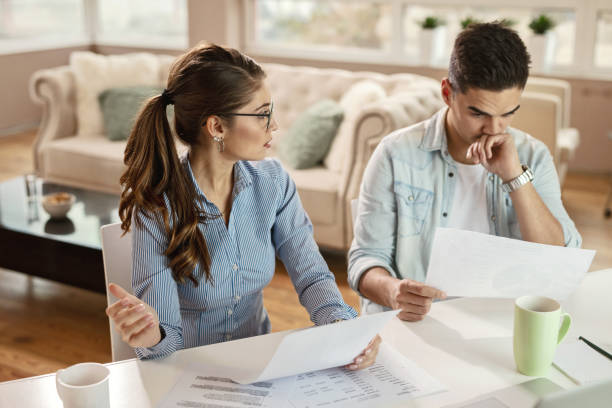istock Young business couple discussing while going thorough paperwork in the office. 1130861952