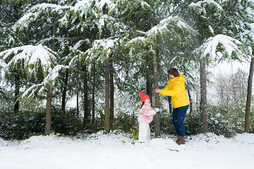 a mother and her daughter playing in the snow