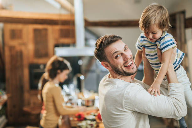 istock Cheerful father having fun while playing with his son at home. 1130868460