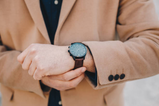istock man checking the time and fixing the belt on his wrist watch. 1130868501