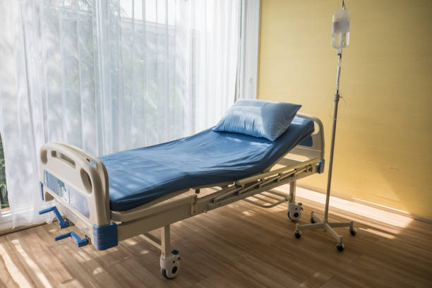 istock Adjustable patient bed in hospital room with warm light. 1130868995
