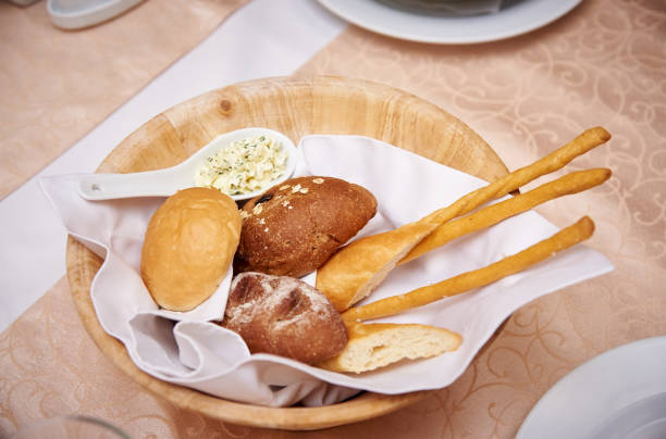 istock Fresh bread in a wooden bowl on a served table. 1130869461