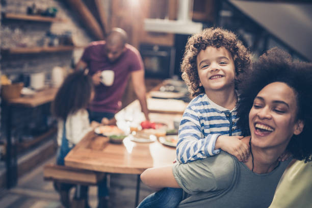 istock Young cheerful mother and her little son having fun while piggybacking in the kitchen. 1130871256