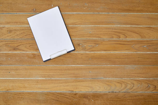 istock Blank white paper on clipboard on wooden table. Top view 1130872593